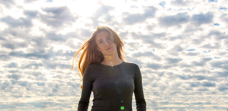 Composer Emma O'Halloran stands in front of a blue sky