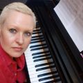 Female with short blonde hair at piano